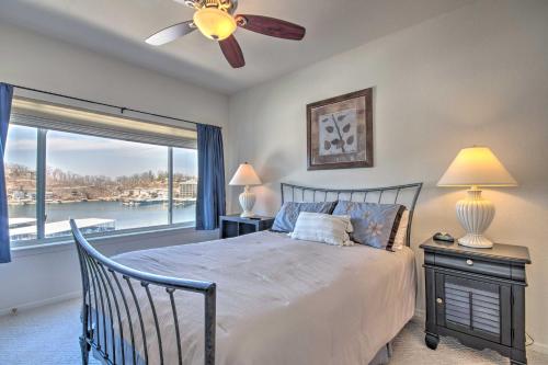 Schlafzimmer mit einem Bett, einem Deckenventilator und einem Fenster in der Unterkunft Boat Slip, Views Waterfront Lake Ozark Condo! in Lake Ozark
