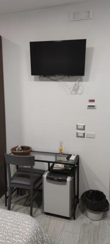 a room with a desk with a television on a wall at Guest House Via Milano in Catanzaro