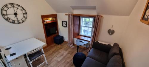 a living room with a couch and a clock on the wall at Kirkwall town centre apartment in Kirkwall