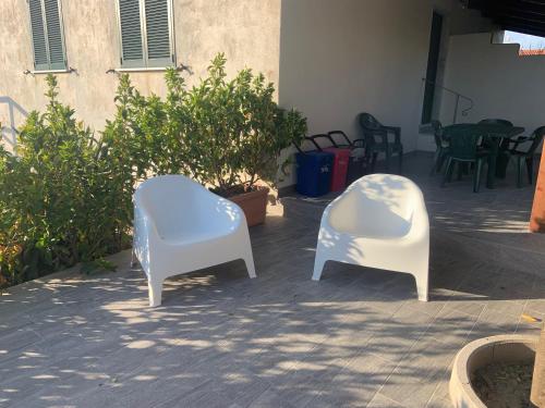 two white chairs sitting next to each other on a patio at Edoardo e Franca in Minturno