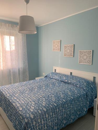a blue bedroom with a bed and a window at Edoardo e Franca in Minturno