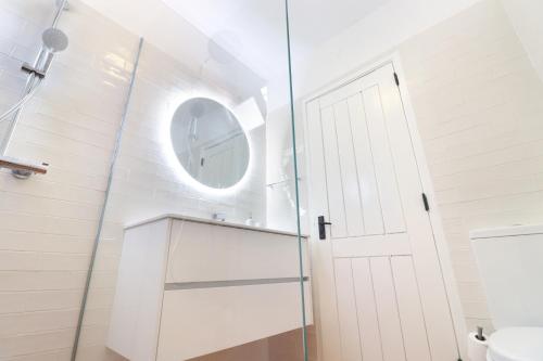 a bathroom with a glass shower door and a mirror at Seagull Rooftop Beach @150 m in Vale do Lobo