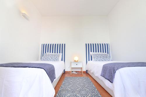dos camas sentadas una al lado de la otra en un dormitorio en Seagull Rooftop Beach @150 m en Vale do Lobo