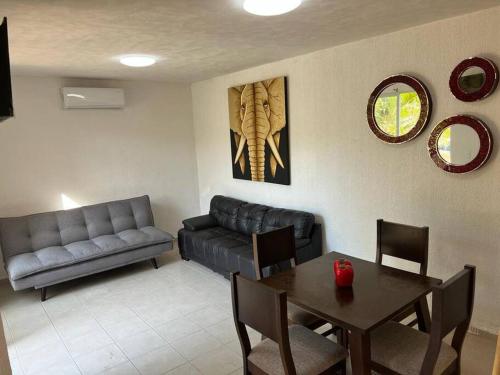 a living room with a couch and a table at New Home Sol, Mar y Arena Ixtapa. in Ixtapa