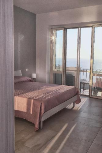 a bedroom with a bed with a view of the ocean at RAMA APARTAMENT in Vico Equense