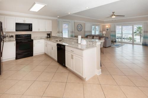 a kitchen with white cabinets and a counter top at Escapes! To The Shores Orange Beach, A Ramada by Wyndham in Orange Beach