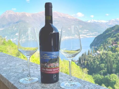 a bottle of wine next to two wine glasses at Hotel Diffuso Il Portichetto sulla collina a Vezio Perledo in Perledo