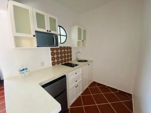 a small kitchen with white cabinets and a sink at Hotel Spa Posada Tlaltenango in Cuernavaca