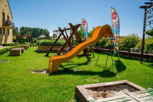 a playground with an orange slide in the grass at Willa Enigma in Dębki