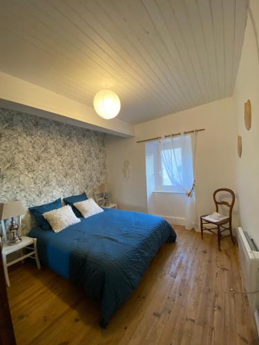 a bedroom with a blue bed and a window at La vieille forge in Boussan