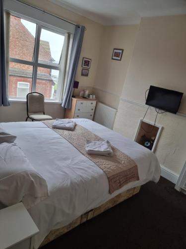 Un dormitorio con una cama grande y una ventana en Winston House en Bridlington