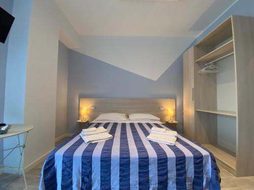 a bedroom with a bed with a blue and white striped blanket at NARANJA in Marina di Schiavonea