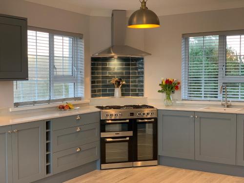 a kitchen with gray cabinets and a stove top oven at The Lake House Dungloe in Dungloe