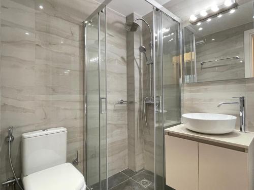 a bathroom with a shower and a toilet and a sink at Athenean Modern Escape near Marina Flisvos in Athens