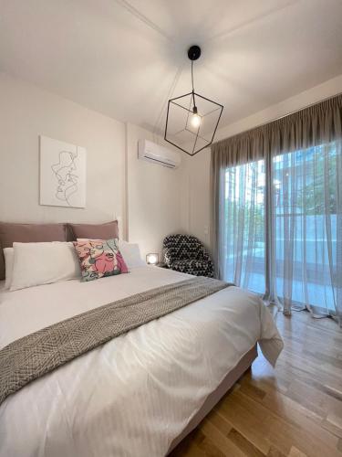 a bedroom with a large bed and a large window at Athenean Modern Escape near Marina Flisvos in Athens
