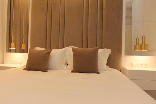 a bed with white sheets and pillows in a room at Adri & Marg luxury living in Athens