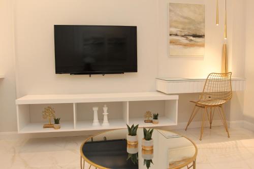sala de estar con TV de pantalla plana en la pared en Adri & Marg luxury living, en Atenas