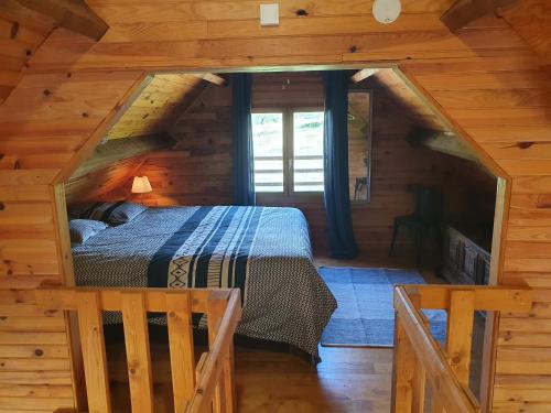 a bedroom in a log cabin with a bed at Moulin Du Pommier Glamping & Camping in Saulgond