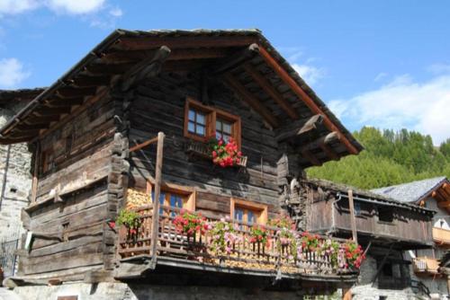 a wooden house with flowers on a balcony at Piccolo e accogliente rascard CIR 0060 in Champoluc