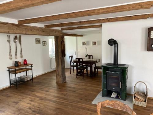 - un salon avec un poêle à bois et une table dans l'établissement La clé du Temps, à Offendorf