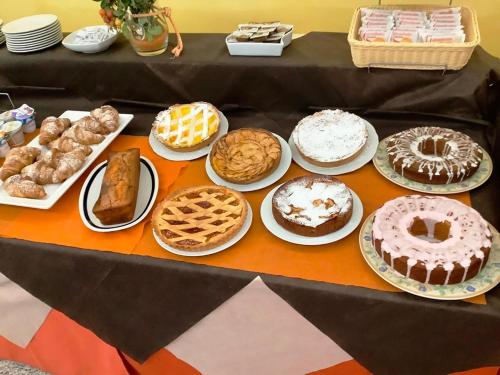 a table with many different types of cakes and pastries at Hotel La Querceta in Montecatini Terme