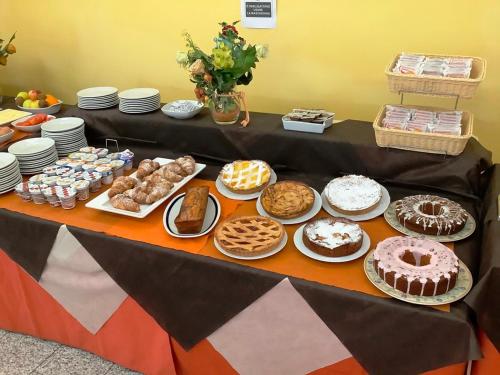 a table with many different types of cakes and pastries at Hotel La Querceta in Montecatini Terme