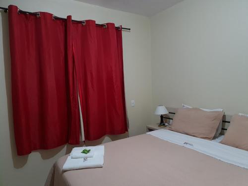 a bedroom with a red curtain and a bed at Pousada Quatro Estações in Alto Paraíso de Goiás