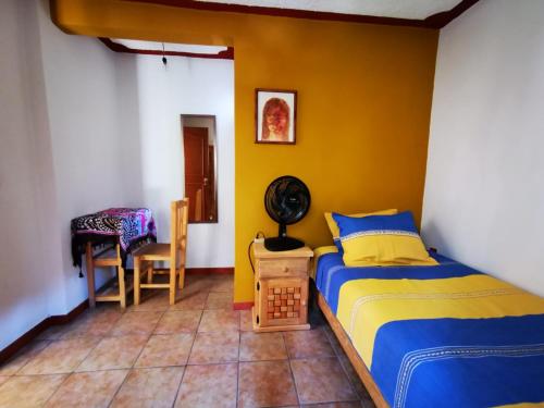 a bedroom with a bed and a yellow wall at Casa Donaji in Oaxaca City