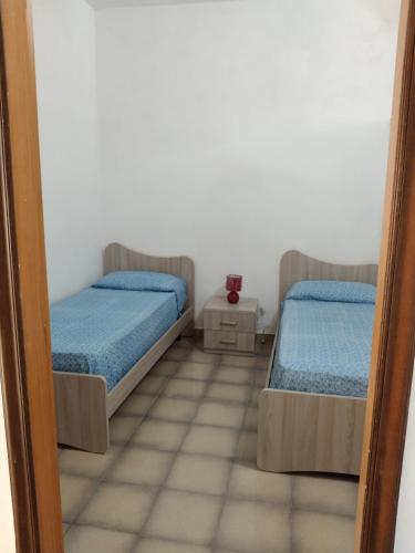 two beds in a room with a mirror at Olga’s house in Cariati