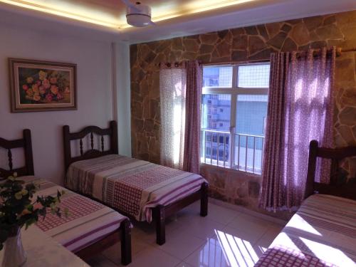 a living room with two beds and a window at Sinta-se em casa na praia do Forte in Cabo Frio