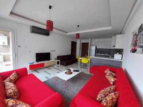 a living room with red couches and a kitchen at Harmony Appartement 13 in Tunis