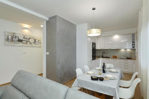 a living room with a couch and a table and a kitchen at Apartment and room Mare in Zadar