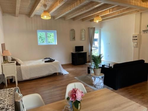 een woonkamer met een bed en een tafel bij Le Chêne: Petit Chalet cosy proche de Mulhouse in Riedisheim