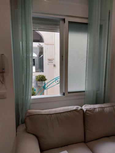 a couch in a living room looking out a window at Loft Escobar in Nerja