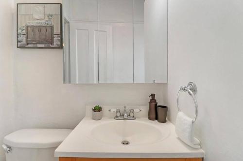 Un baño con lavabo, inodoro y espejo. en City Charm Studio Apt close to Shops - Ashland 04, en Chicago