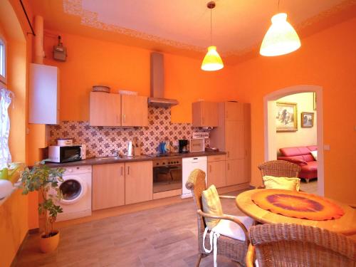 a kitchen with orange walls and a table in a room at Märchenhaft urlauben auf dem Alpakahof in Rambow