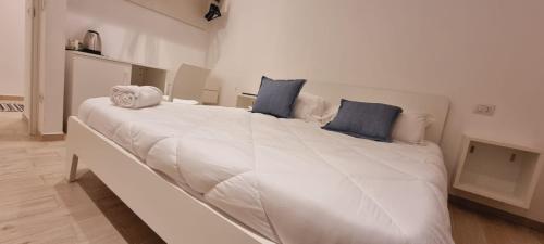 a large white bed with blue pillows in a room at A casa di Maghi in Olbia
