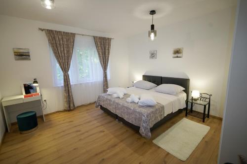 1 dormitorio con 1 cama grande con almohadas blancas en Apartment Ana, en Split