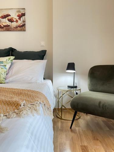 a bedroom with a bed and a chair at Athenean Modern Escape near Marina Flisvos in Athens