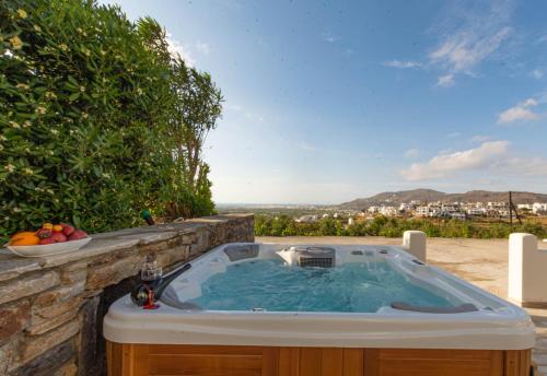 a jacuzzi tub sitting on a stone wall at Villa Di Sergio in Glinado Naxos