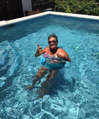 a man in a swimming pool in a swimming pool at Ocean Breeze in Placencia Village