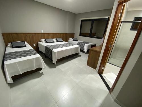 a bedroom with three beds in a room at VIPPER Hotel in Aparecida