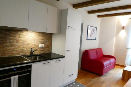 cocina con silla roja en una habitación en Hôtel St-Georges Romont, en Romont