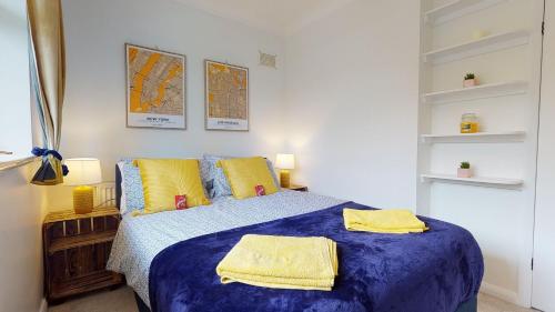 a bedroom with a blue bed with yellow pillows at Contemporary 2 Bed Apartment With Private Garden in Maidstone