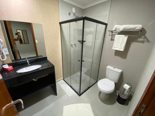 a bathroom with a shower and a toilet and a sink at VIPPER Hotel in Aparecida