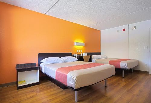Duas camas num quarto com paredes cor de laranja em Motel 6-East Brunswick, NJ em East Brunswick