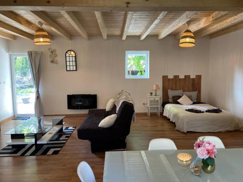 a living room with a couch and a bed at Le Noyer: Petit chalet cosy proche de Mulhouse in Riedisheim