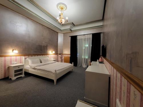 a bedroom with a bed and a chandelier at NF Palace Old City Bucharest in Bucharest