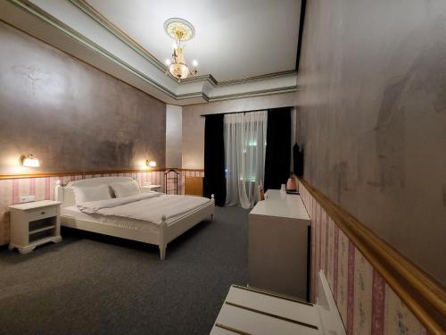 a bedroom with a bed and a chandelier at NF Palace Old City Bucharest in Bucharest