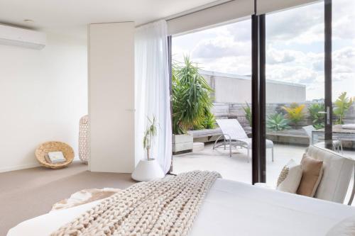 a bedroom with a bed and a large window at Architectural Home, Pool Oasis/ Steps from Trendy Chapel St. in Melbourne